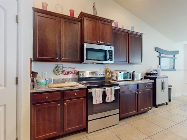 9677 SW 56th Cir, Ocala, FL 34476 - kitchen with stainless steel appliances, light tile patterned flooring, lofted ceiling, and light countertops