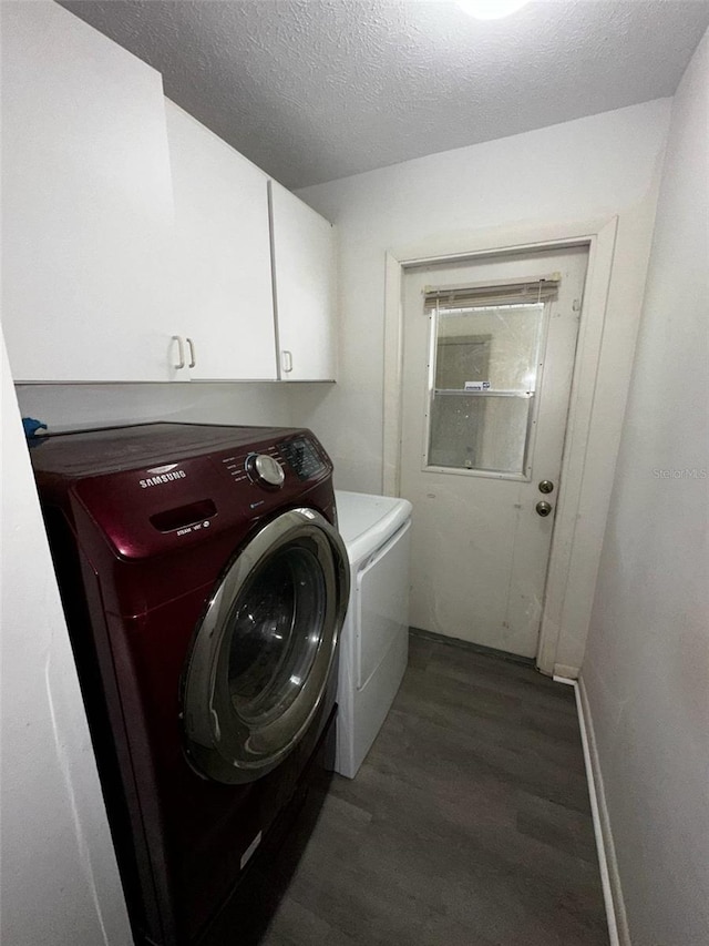 laundry room featuring washer and clothes dryer, wood finished floors, cabinet space, a textured ceiling, and baseboards