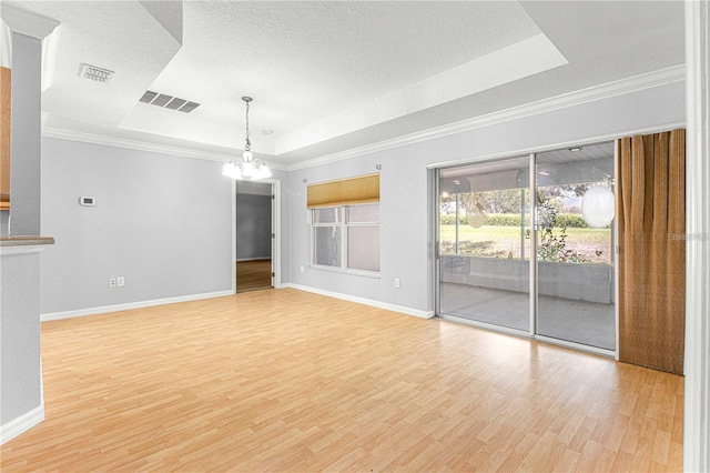 9287 SW 91st Court Rd, Ocala, FL 34481 - spare room featuring a tray ceiling, a chandelier, light wood-type flooring, baseboards, and ornamental molding