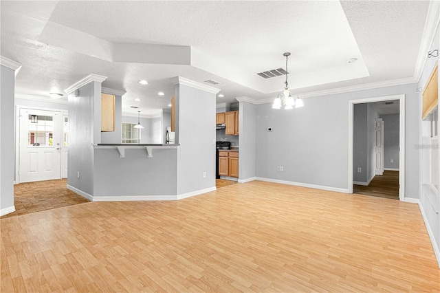 9287 SW 91st Court Rd, Ocala, FL 34481 - unfurnished living room featuring a chandelier, light wood-type flooring, ornamental molding, a tray ceiling, and baseboards