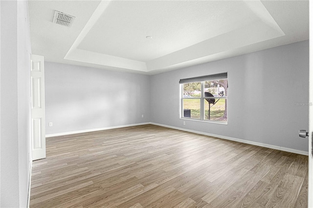 9287 SW 91st Court Rd, Ocala, FL 34481 - spare room featuring a tray ceiling, wood finished floors, and baseboards