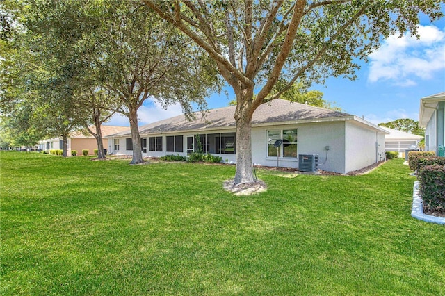 9287 SW 91st Court Rd, Ocala, FL 34481 - back of property featuring central AC unit, a yard, and stucco siding