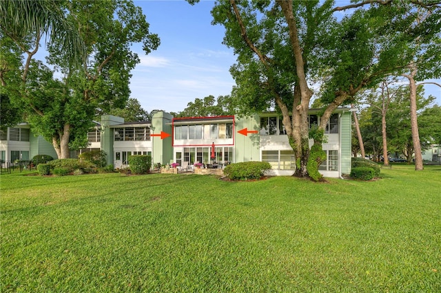 rear view of property with a yard