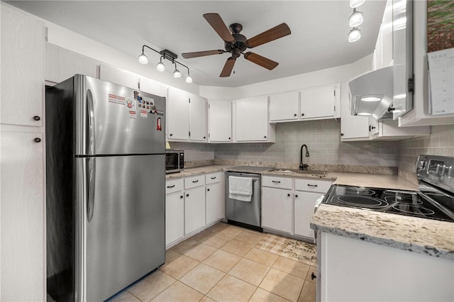 kitchen featuring stainless steel appliances, a sink, a ceiling fan, light tile patterned flooring, and tasteful backsplash