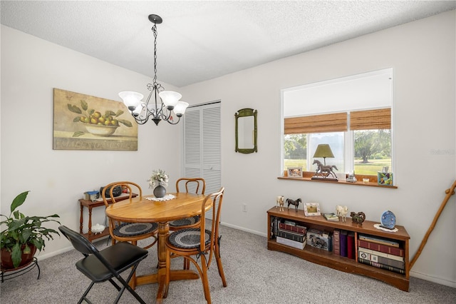 dining space featuring a chandelier, carpet, baseboards, and a textured ceiling