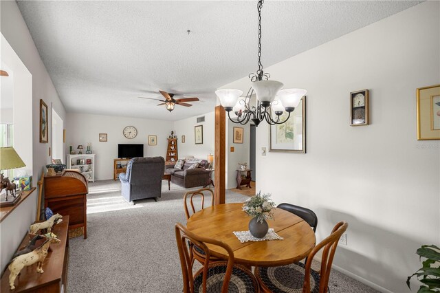 dining room with carpet flooring, a textured ceiling, a chandelier, and a ceiling fan