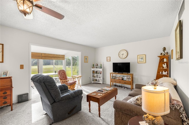 living area with carpet floors, a textured ceiling, and a ceiling fan