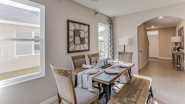 8659 SW 44th Ter, Ocala, FL 34476 - dining room featuring arched walkways, baseboards, and light tile patterned floors