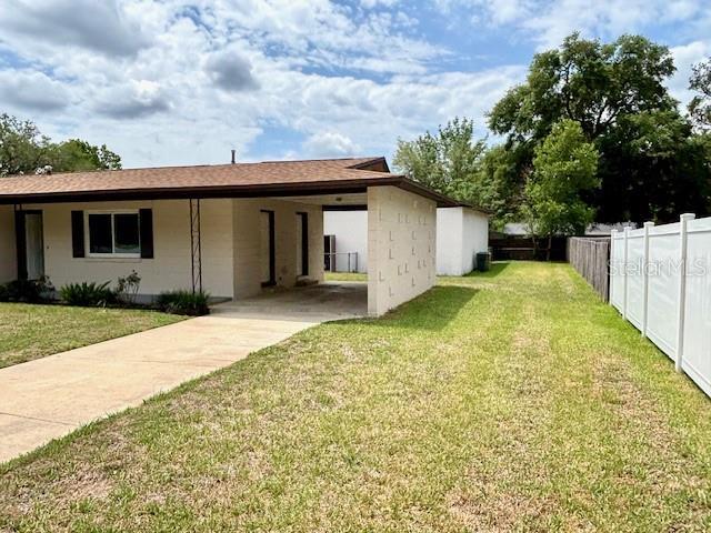 back of house featuring a carport