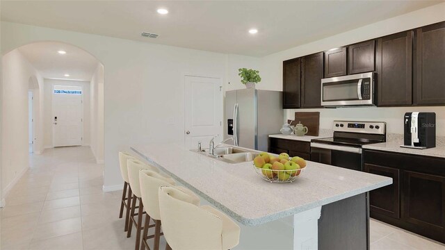 4235 SW 53rd Lane Rd, Ocala, FL 34474 - kitchen featuring stainless steel appliances, a sink, arched walkways, a center island with sink, and a kitchen bar