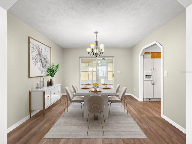 10739 SE 44th Ter, Belleview, FL 34420 - dining space with wood finished floors, baseboards, a chandelier, and a textured ceiling