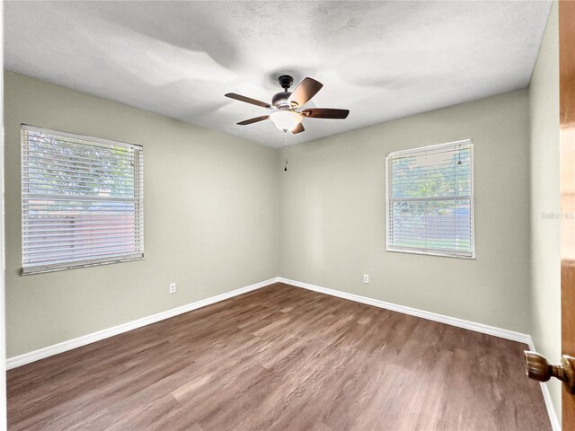10739 SE 44th Ter, Belleview, FL 34420 - spare room with dark wood finished floors, a ceiling fan, and baseboards