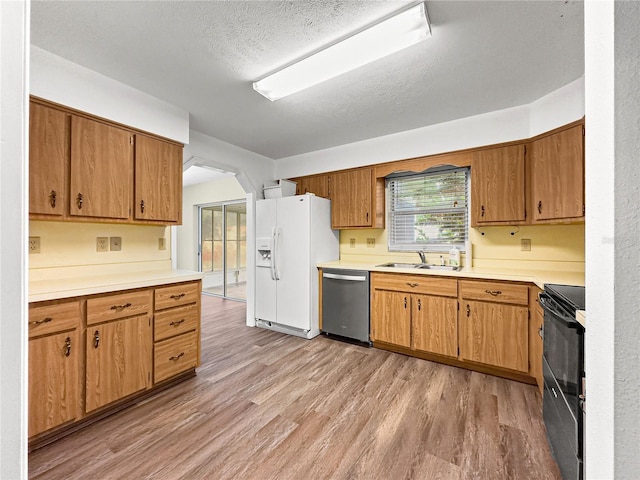 10739 SE 44th Ter, Belleview, FL 34420 - kitchen featuring dishwasher, white fridge with ice dispenser, black range with electric stovetop, a sink, and light wood-style floors