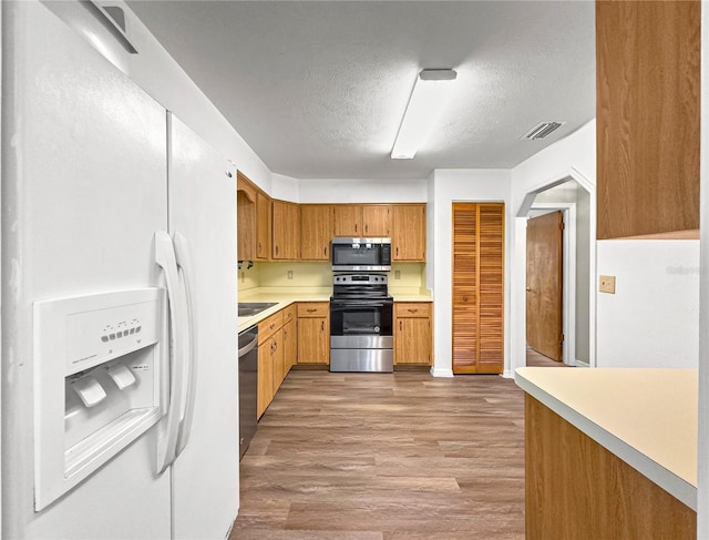 10739 SE 44th Ter, Belleview, FL 34420 - kitchen featuring stainless steel appliances, a textured ceiling, light countertops, and light wood-type flooring