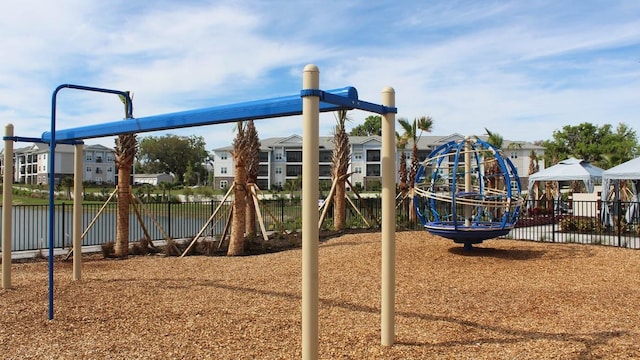 communal playground featuring fence and a residential view
