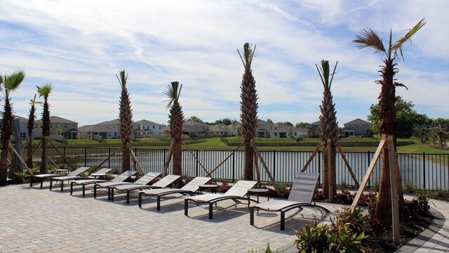 view of patio featuring a residential view, a fenced backyard, and a water view