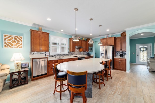 6868 SW 95th Cir, Ocala, FL 34481 - kitchen featuring stainless steel appliances, ornamental molding, arched walkways, tasteful backsplash, and a kitchen bar