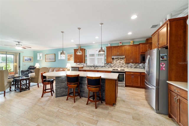 6868 SW 95th Cir, Ocala, FL 34481 - kitchen featuring stainless steel appliances, open floor plan, plenty of natural light, light countertops, and ornamental molding
