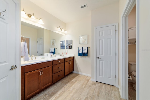 6868 SW 95th Cir, Ocala, FL 34481 - full bathroom featuring wood finished floors, double vanity, toilet, and baseboards