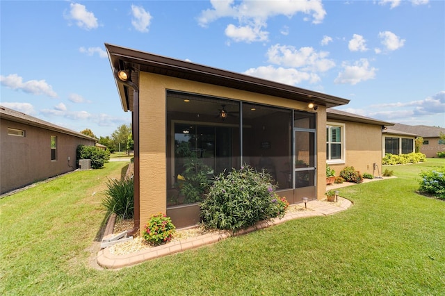 6868 SW 95th Cir, Ocala, FL 34481 - back of property featuring stucco siding, a sunroom, and a lawn