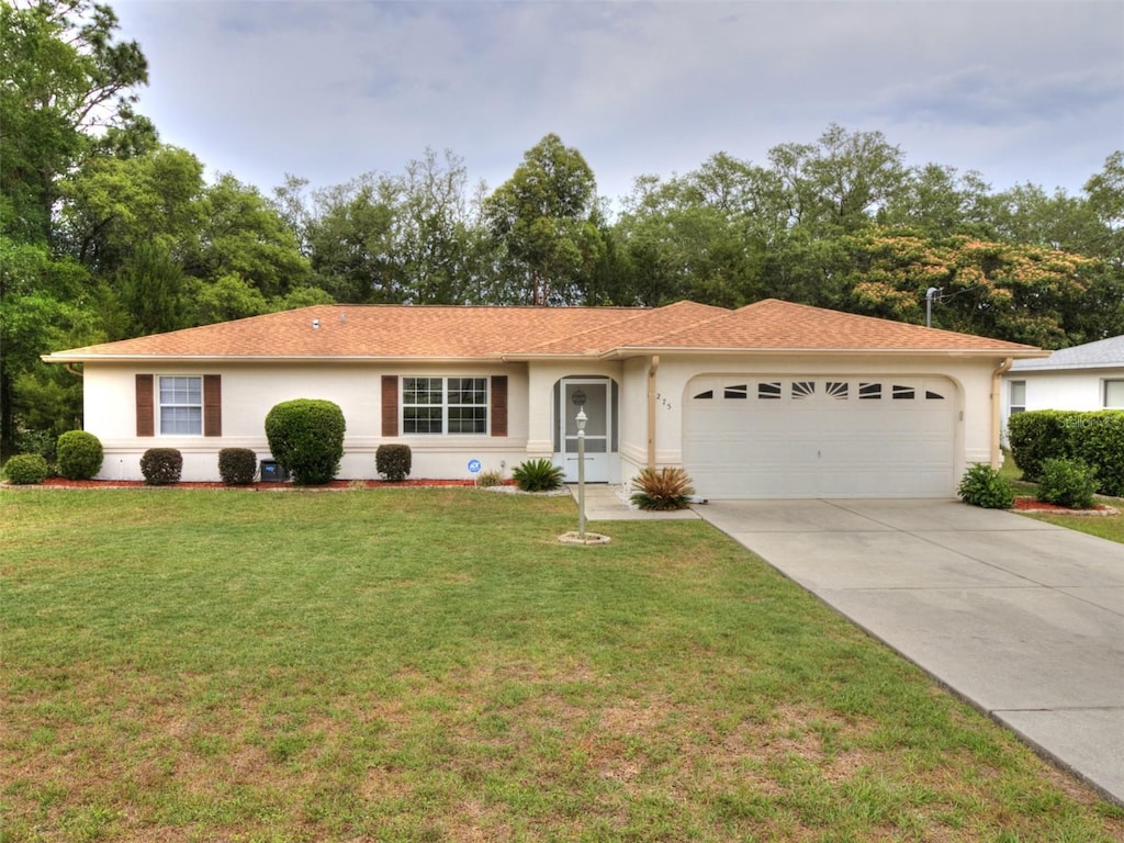 275 W Baker Pl, Citrus Springs, FL 34434 - ranch-style house featuring a garage, stucco siding, driveway, and a front yard