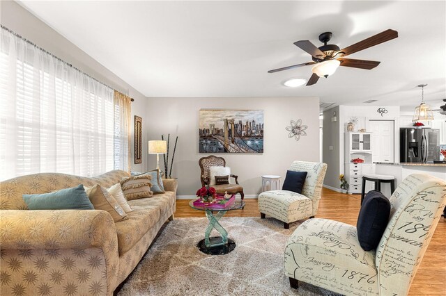 8874 SW 95th St Unit E, Ocala, FL 34481 - living area featuring light wood-style floors, a ceiling fan, and baseboards