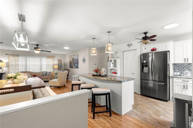 8874 SW 95th St Unit E, Ocala, FL 34481 - kitchen with stainless steel refrigerator with ice dispenser, ceiling fan, backsplash, white cabinets, and a center island