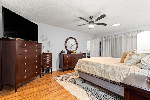 8874 SW 95th St Unit E, Ocala, FL 34481 - bedroom with light wood-style floors, a textured ceiling, and a ceiling fan