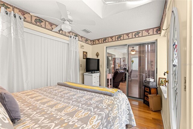8874 SW 95th St Unit E, Ocala, FL 34481 - bedroom with light wood-style floors, ceiling fan, a textured ceiling, and a closet