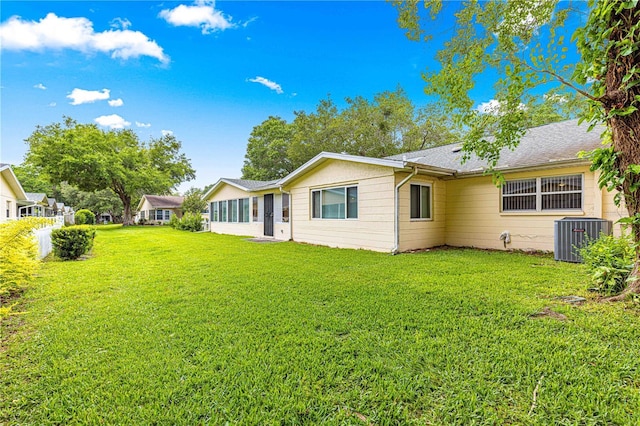 8874 SW 95th St Unit E, Ocala, FL 34481 - back of house featuring central AC and a lawn