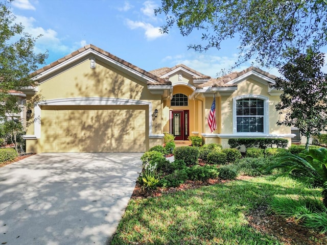 view of front facade with stucco siding, a garage, driveway, and a tiled roof