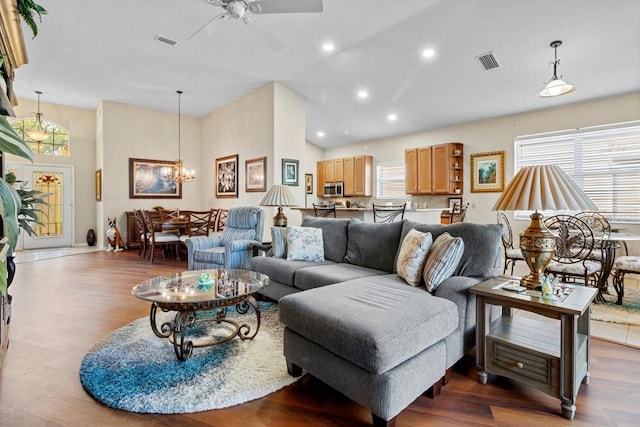 living room with high vaulted ceiling, wood finished floors, ceiling fan, recessed lighting, and a chandelier