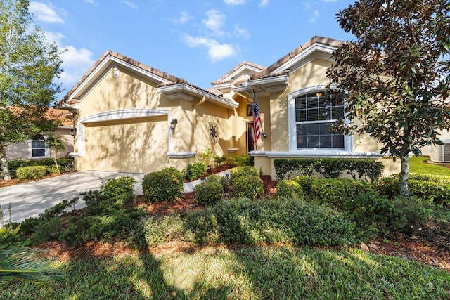 view of front facade with stucco siding, concrete driveway, a garage, and a tile roof