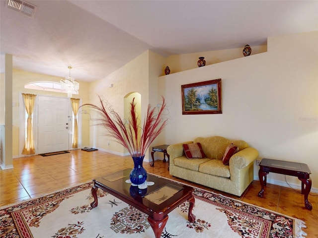 9325 SW 125th Court Rd, Dunnellon, FL 34432 - living room with vaulted ceiling, tile patterned floors, baseboards, and a chandelier