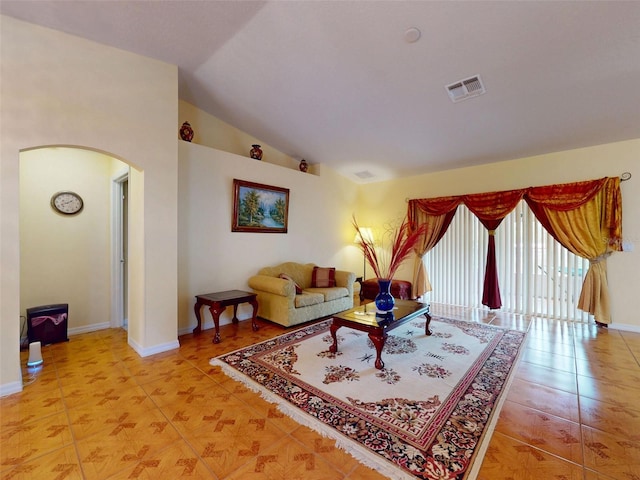 9325 SW 125th Court Rd, Dunnellon, FL 34432 - living room featuring arched walkways, light tile patterned floors, lofted ceiling, and baseboards