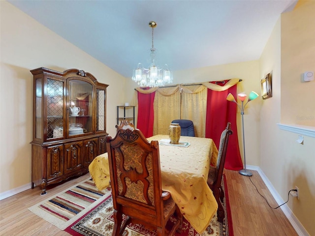9325 SW 125th Court Rd, Dunnellon, FL 34432 - dining area with a chandelier, wood finished floors, baseboards, and lofted ceiling