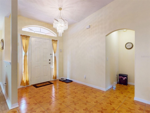 9325 SW 125th Court Rd, Dunnellon, FL 34432 - foyer with arched walkways, a chandelier, light tile patterned flooring, and baseboards