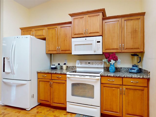 9325 SW 125th Court Rd, Dunnellon, FL 34432 - kitchen with white appliances, brown cabinetry, and dark stone counters