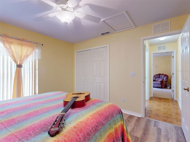 9325 SW 125th Court Rd, Dunnellon, FL 34432 - bedroom featuring light wood finished floors, a closet, baseboards, attic access, and ceiling fan