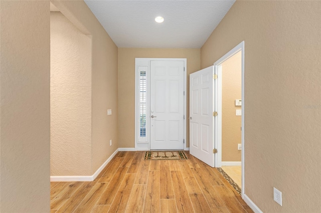 6651 SW 93rd Ct, Ocala, FL 34481 - foyer entrance featuring light wood-style floors, a textured wall, and baseboards