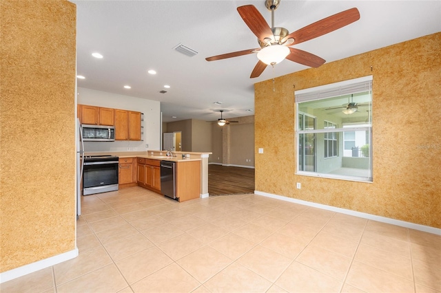 6651 SW 93rd Ct, Ocala, FL 34481 - kitchen with stainless steel appliances, a peninsula, open floor plan, baseboards, and a ceiling fan