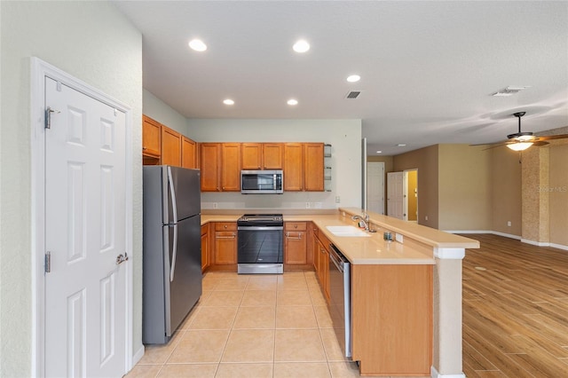 6651 SW 93rd Ct, Ocala, FL 34481 - kitchen with stainless steel appliances, a sink, a peninsula, open floor plan, and light countertops