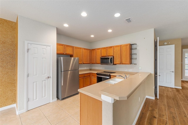 6651 SW 93rd Ct, Ocala, FL 34481 - kitchen with stainless steel appliances, open shelves, a peninsula, light countertops, and baseboards