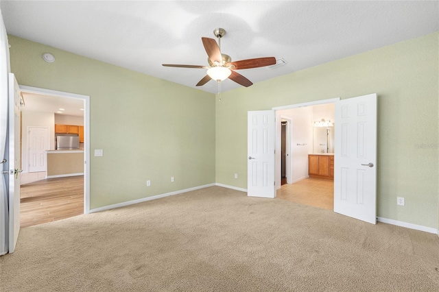 6651 SW 93rd Ct, Ocala, FL 34481 - unfurnished bedroom featuring stainless steel refrigerator, light colored carpet, baseboards, ensuite bath, and ceiling fan