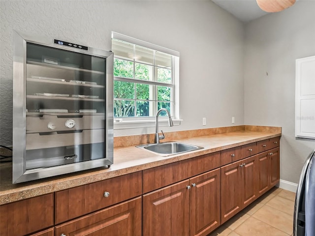 2540 NE 120th St, Anthony, FL 32617 - kitchen featuring a sink, wine cooler, light tile patterned floors, light countertops, and brown cabinetry