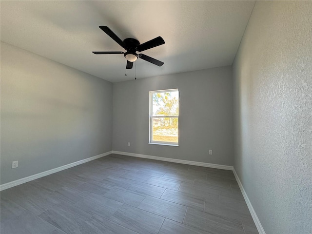unfurnished room with a ceiling fan and baseboards