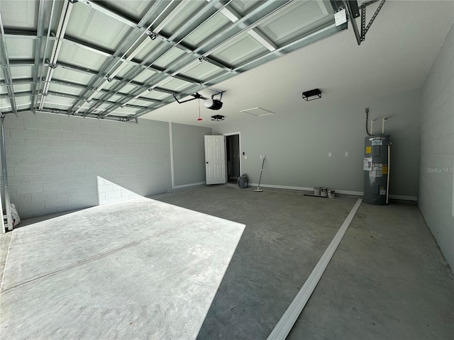 garage with electric water heater, a garage door opener, and concrete block wall