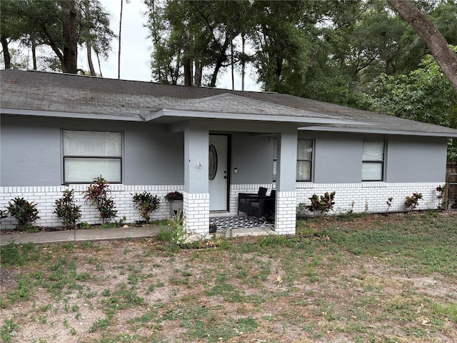 5549 NW 64th St, Ocala, FL 34482 - view of front of house featuring brick siding, stucco siding, roof with shingles, and covered porch