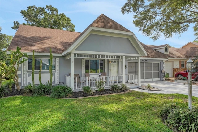 view of front facade featuring covered porch, concrete driveway, an attached garage, and a front lawn