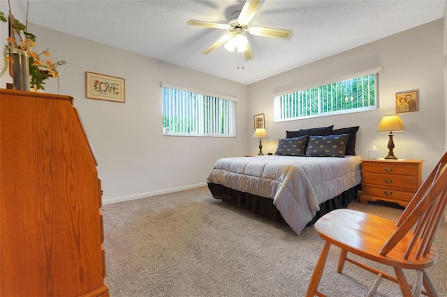 bedroom featuring carpet flooring, baseboards, a textured ceiling, and a ceiling fan
